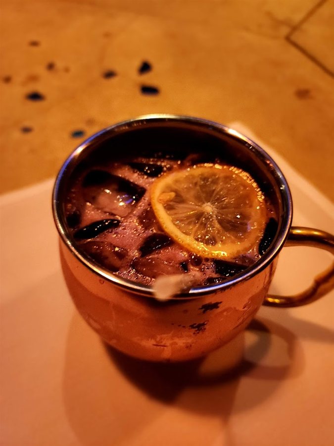 Cocktail in a copper mug garnished with citrus